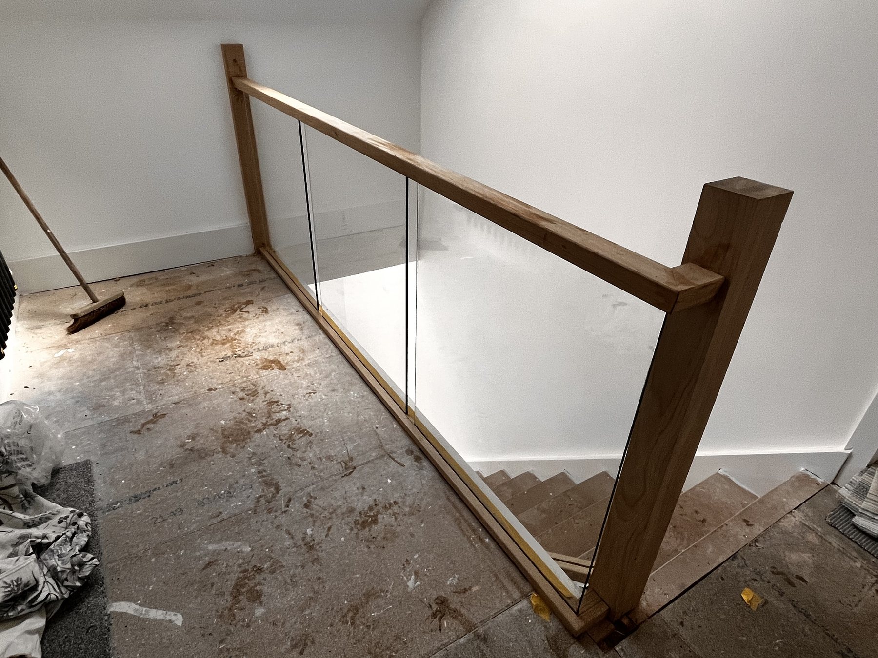 Oak and glass staircase landing renovation with clear glass panels