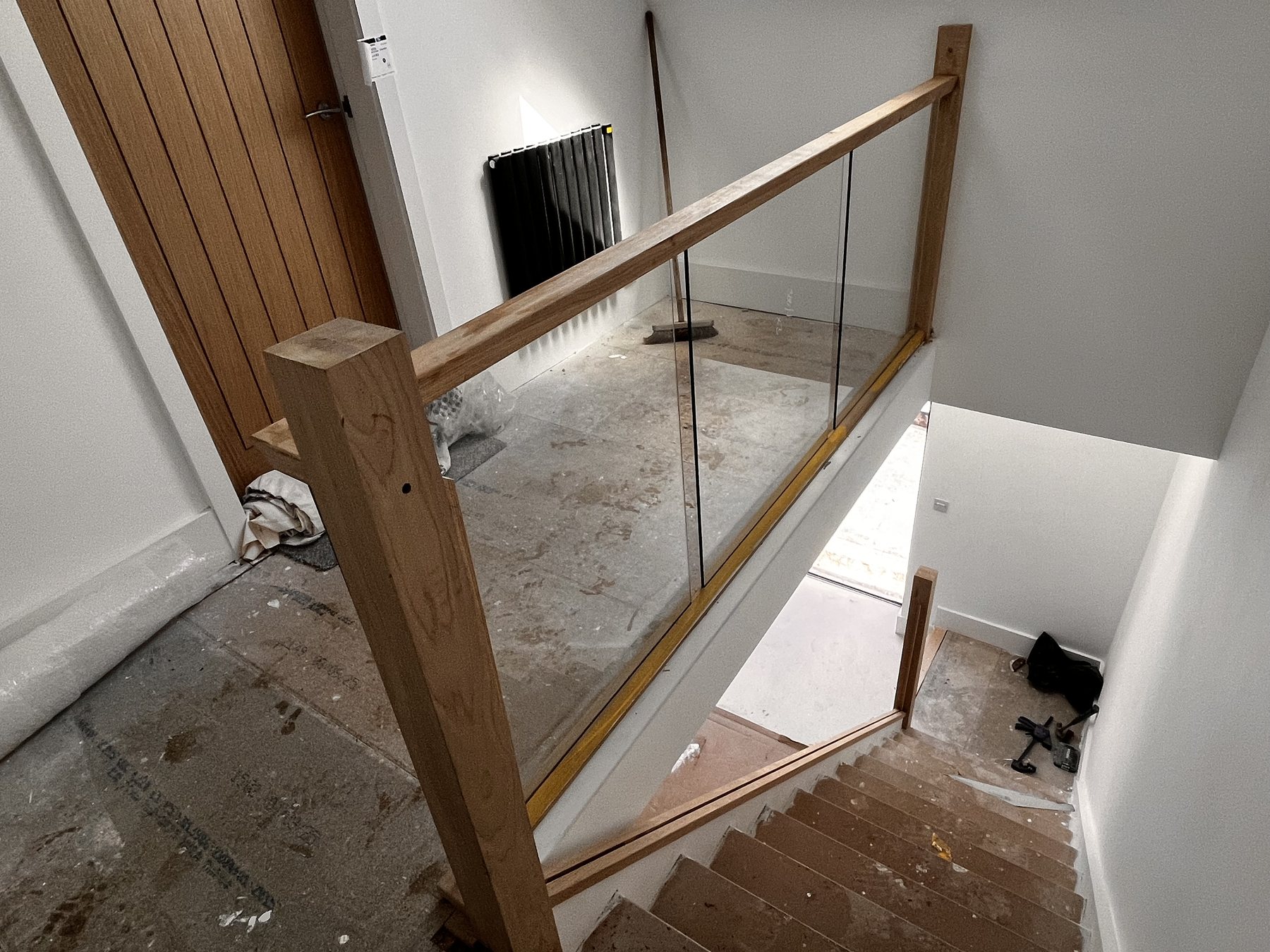 Wide view of oak and glass staircase renovation with clear glass panels