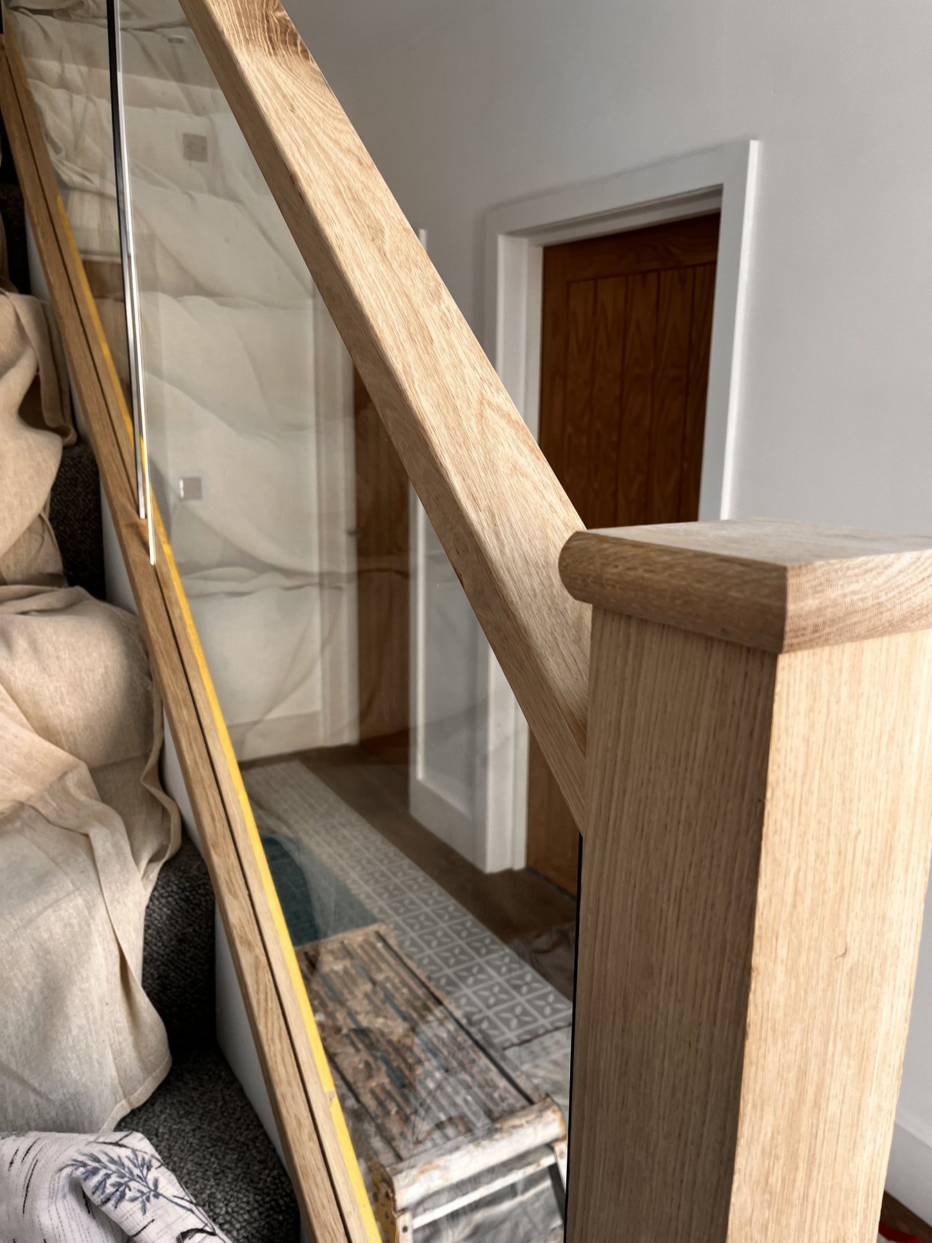 Close-up oak handrail and clear glass panel detail